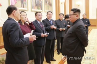 Who are nine NK officials accompanying Kim Jong-un?