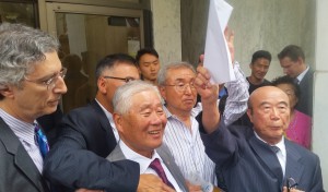딸을 방화·살해한 혐의로 25년동안 감옥살이를 한 뒤 22일(현지시간) 보석으로 풀려난 이한탁(79, 앞줄 가운데)씨가 법원 건물을 나와 소감문을 읽은 뒤 환하게 웃고 있다.(해리스버그=연합뉴스)