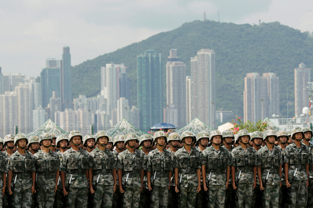 홍콩의 스톤커터교 해군기지에 도열한 중국 인민해방군 너머로 홍콩의 대형 빌딩들이 늘어서 있다[로이터=헤럴드경제]