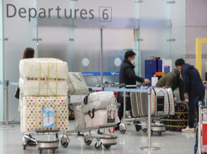 지난 4일 오후 인천국제공항에서 공항 이용객들이 마스크가 든 수레를 운반하고 있다. [연합=헤럴드경제]