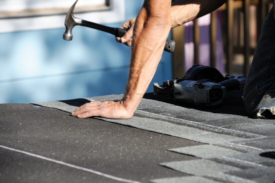 handyman working on repairing roof