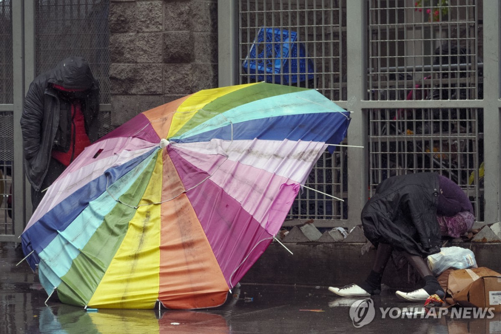 LA 길거리에 노숙인들이 비 내리는 길가에 웅크리고 앉아있다. (AP=연합)