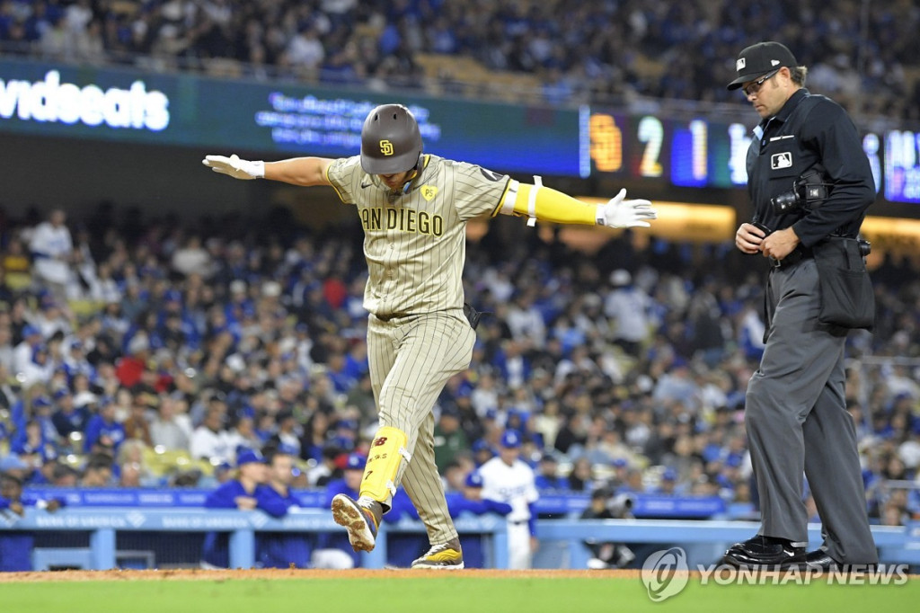 김하성이 2회초 솔로홈런을 날리고 홈인하며  두 팔을 벌리고 있다.[AP=연합]