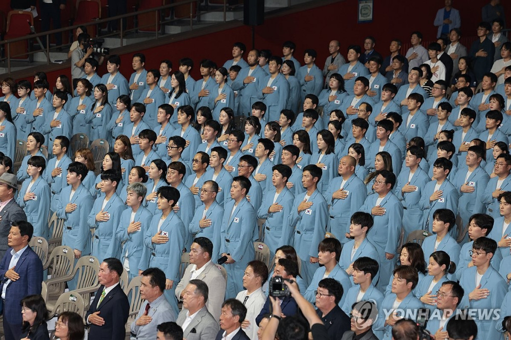  9일 오후 서울 송파구 올림픽공원 올림픽홀에서 열린 2024 파리하계올림픽대회 결단식에서 국가대표 선수와 참석자들이 국기에 경례하고 있다.(연합)