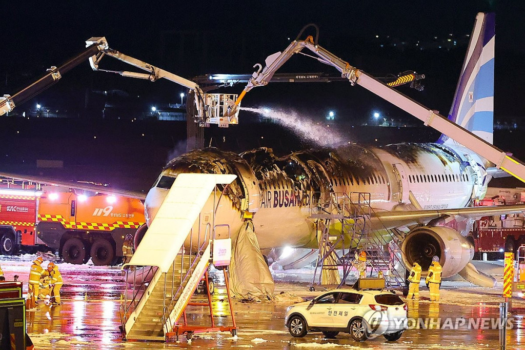 28일 오후 김해공항 계류장에서 승객 170명과 승무원 6명을 태우고 이륙을 준비하던 홍콩행 에어부산 항공기 BX391편 꼬리 쪽 내부에서 불이 나 소방대원들이 진화 작업을 하고 있다.[김해=연합]