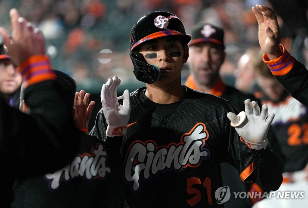 이정후가 22일 밀워키 브루어스와 치른 경기에서 득점한 뒤 덕아웃에서 동료들과 하이파이브를 나누고 있다.[AFP=연합]