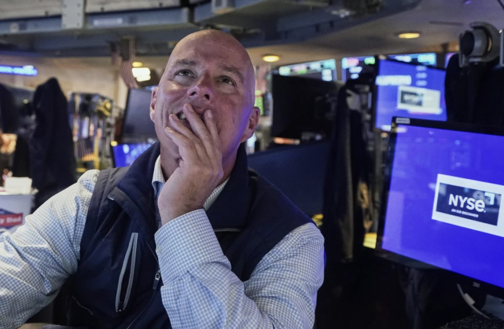 뉴욕증권 거래소의 한 트레이더가 시황을 지켜보며 웃음 띤 표정을 짓고 있다.[AP=연합 자료]