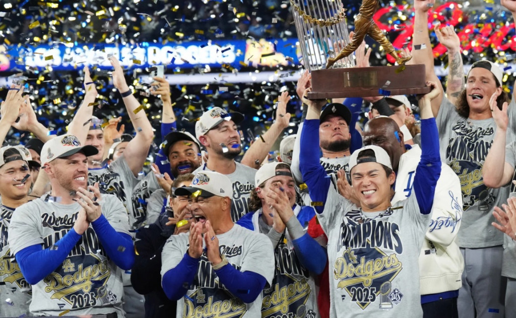 야마모토 요시노부가 데이브 로버츠 감독과 동료 선수들이 박수를 치는 가운데 월드시리즈 MVP 트로피를 치켜들고 있다.[AP=연합]