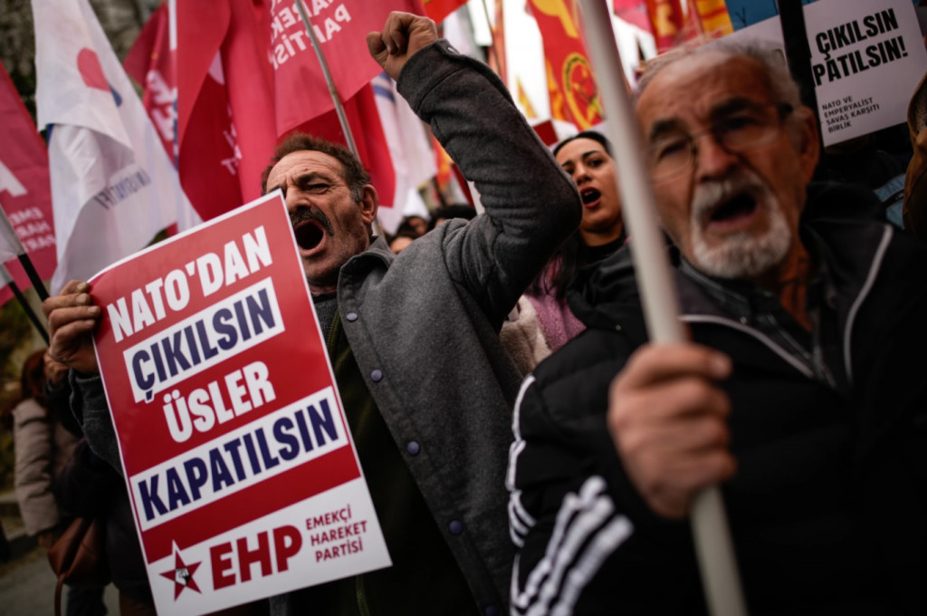 터키 이스탄불에 있는 미국 영사관 앞에서 15일(현지시간) 열린 반미·반이스라엘 시위에서 사람들이 구호를 외치고 있다. 팻말에는 터키어로 "나토에서 나가라, 기지를 폐쇄하라"라고 적혀 있다. (AP=연합)