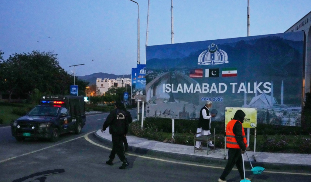 4월 12일 파키스탄 이슬라마바드에서 열린 미-이란 종전협상을 알리는 입간판 주변을 현지인들이 청소하고 있다.[AP=연합 자료]