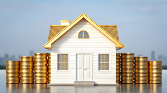 A modern house with a golden roof stands amid tall stacks