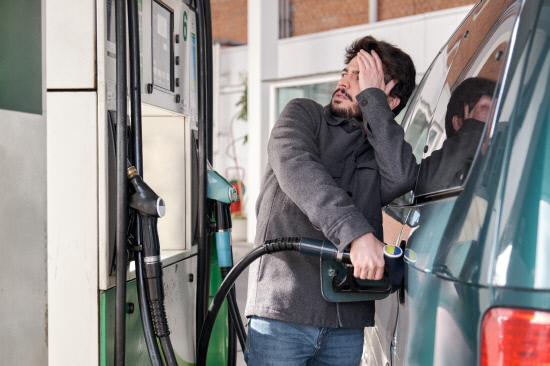 Young man refueling his vehicle