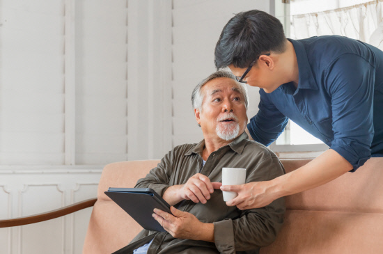 senior asian father and middle aged son
